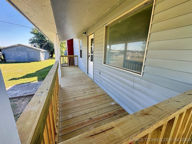 wooden terrace with a lawn