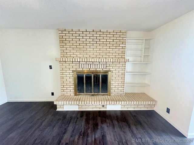 unfurnished living room featuring a fireplace and dark wood-type flooring