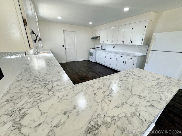 kitchen featuring dark hardwood / wood-style floors, sink, white cabinetry, kitchen peninsula, and white appliances