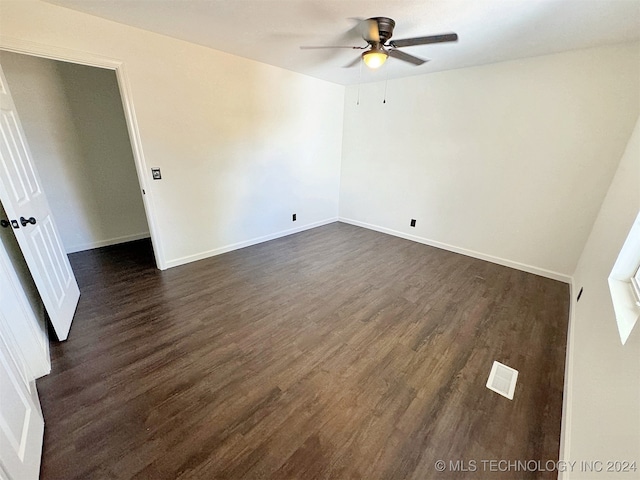 spare room featuring ceiling fan and dark wood-type flooring