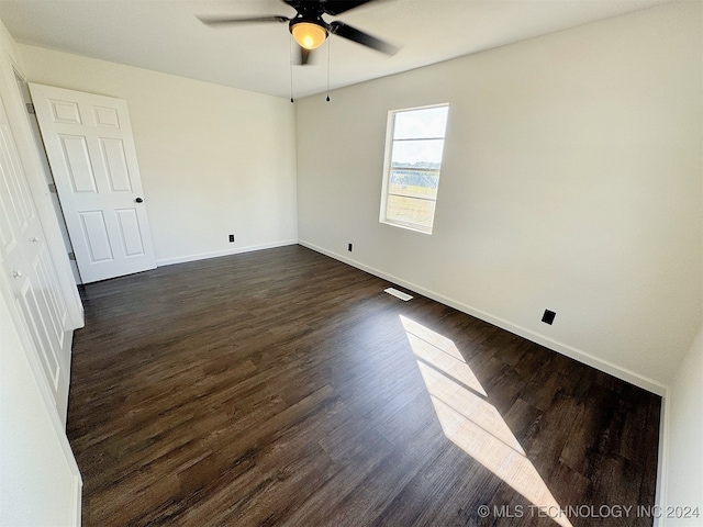 unfurnished room featuring ceiling fan and dark wood-type flooring