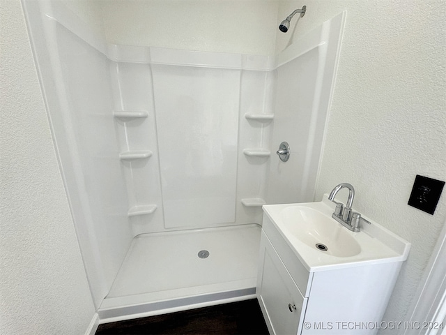 bathroom with walk in shower and vanity