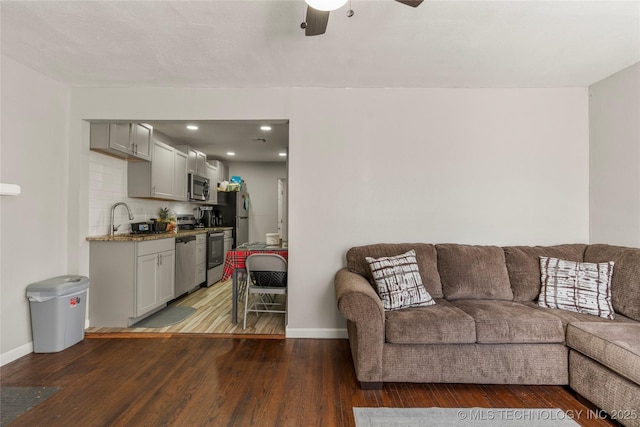 living room featuring recessed lighting, baseboards, wood finished floors, and a ceiling fan