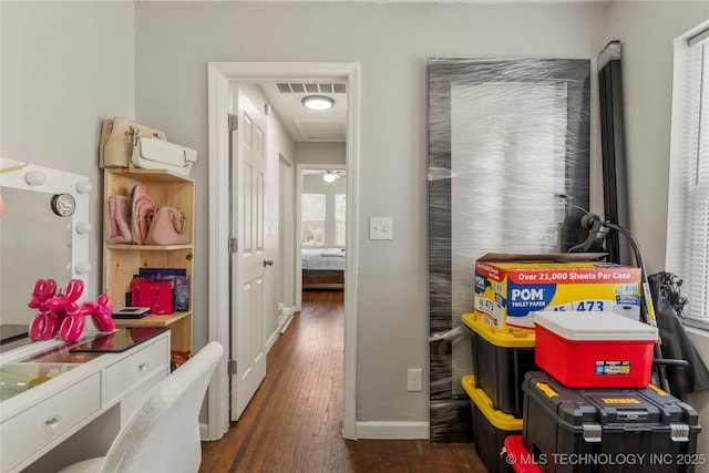 interior space with visible vents, dark wood-type flooring, and baseboards