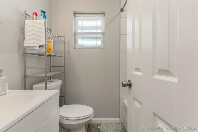 bathroom with baseboards, toilet, vanity, and bathing tub / shower combination