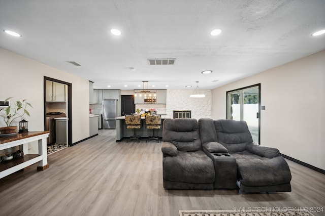 living room featuring a textured ceiling and light wood-type flooring