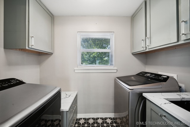 clothes washing area featuring cabinets, sink, and washing machine and clothes dryer