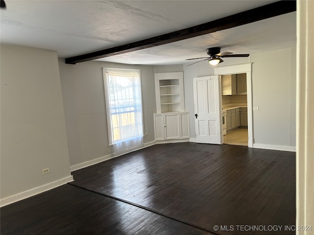 spare room featuring ceiling fan, beamed ceiling, built in features, and dark wood-type flooring