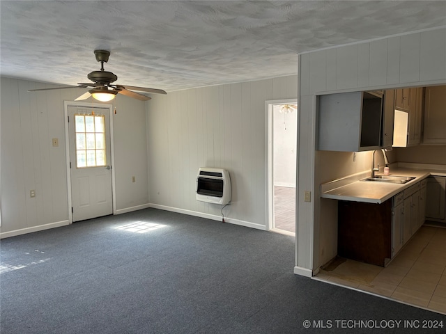 interior space featuring heating unit, carpet flooring, sink, and ceiling fan