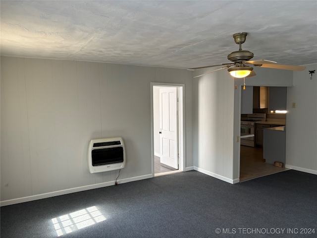 carpeted empty room featuring ceiling fan and heating unit