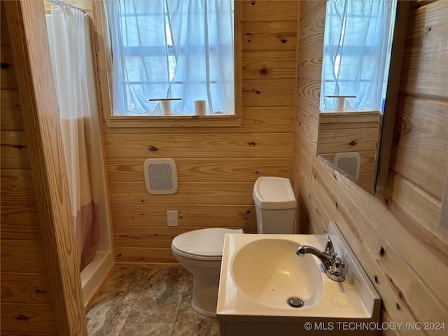 bathroom featuring a shower with curtain, vanity, wood walls, and toilet