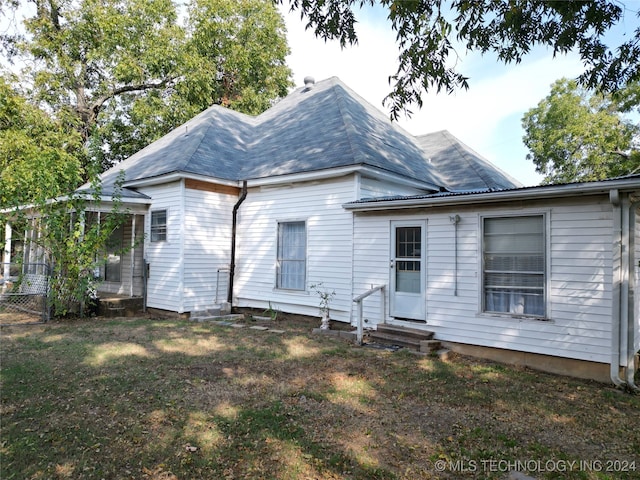 rear view of house with a yard