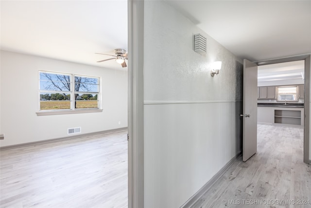 hallway with light hardwood / wood-style floors