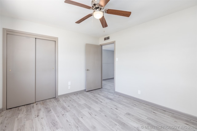 unfurnished bedroom featuring a closet, light wood-type flooring, and ceiling fan