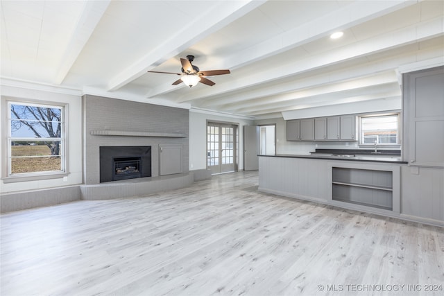 kitchen with light hardwood / wood-style flooring, beam ceiling, and a healthy amount of sunlight