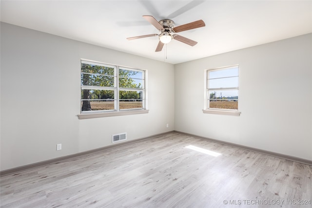 spare room with a wealth of natural light, light hardwood / wood-style floors, and ceiling fan