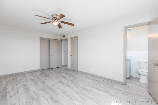 unfurnished bedroom with tile walls, connected bathroom, a closet, ceiling fan, and light hardwood / wood-style flooring