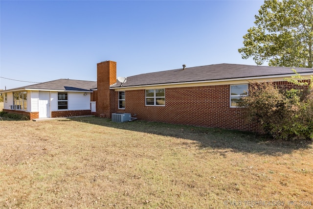 back of house featuring central AC and a yard