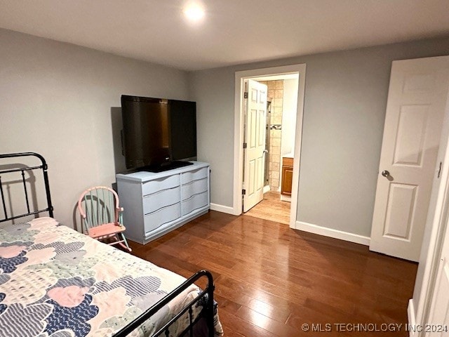 bedroom featuring ensuite bathroom and hardwood / wood-style floors