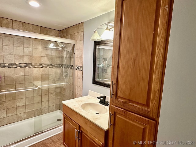 bathroom with wood-type flooring, vanity, a shower with door, and ceiling fan