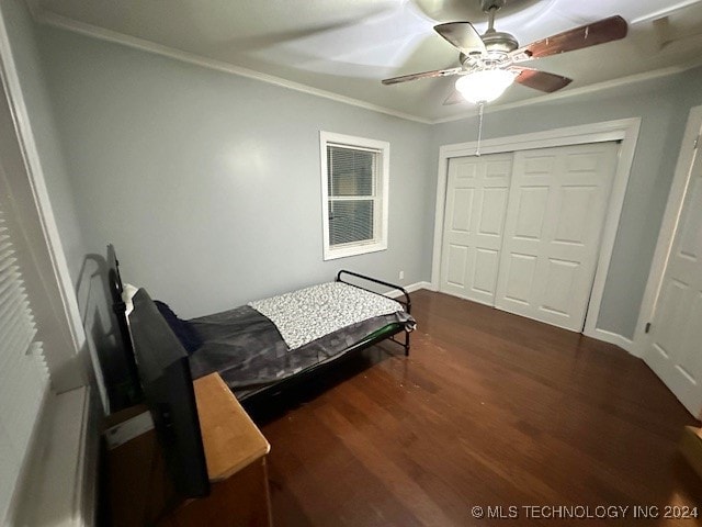 bedroom with ornamental molding, a closet, ceiling fan, and dark hardwood / wood-style floors