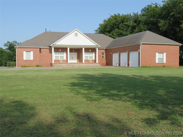 view of front facade with a garage, covered porch, and a front lawn