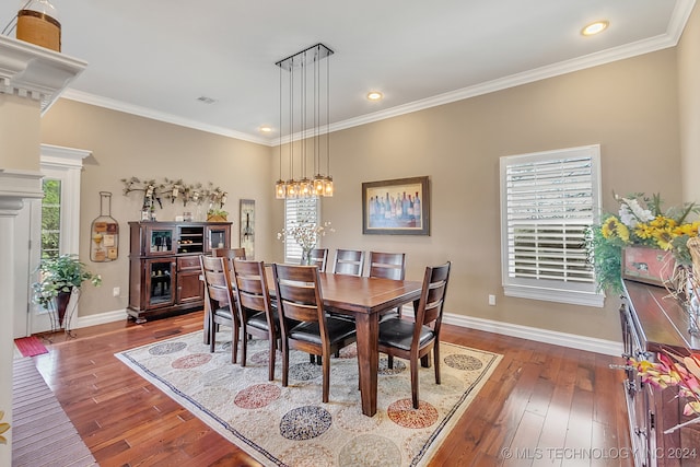 dining room with a wealth of natural light, dark wood-type flooring, and crown molding