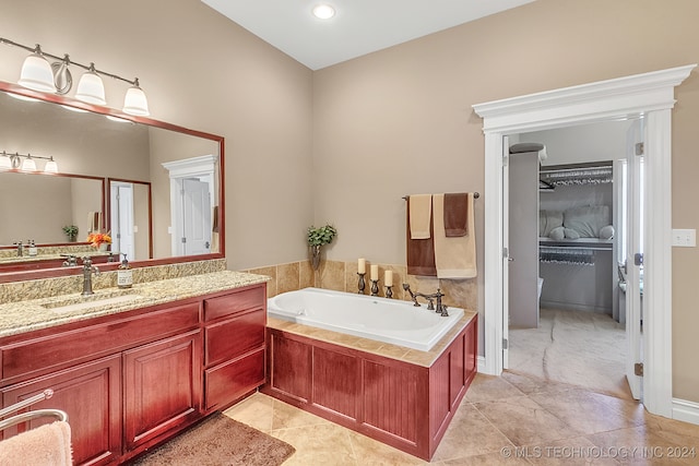 bathroom with vanity, tiled bath, and tile patterned flooring