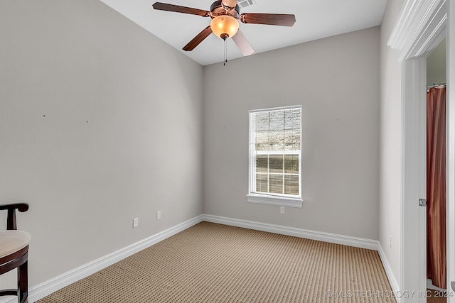 carpeted spare room featuring ceiling fan