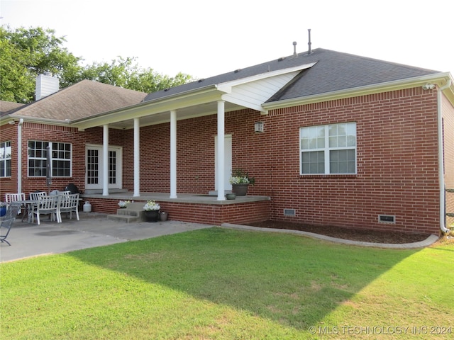 rear view of house featuring a patio area and a yard