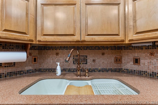 room details featuring light stone countertops, sink, light brown cabinets, and tasteful backsplash