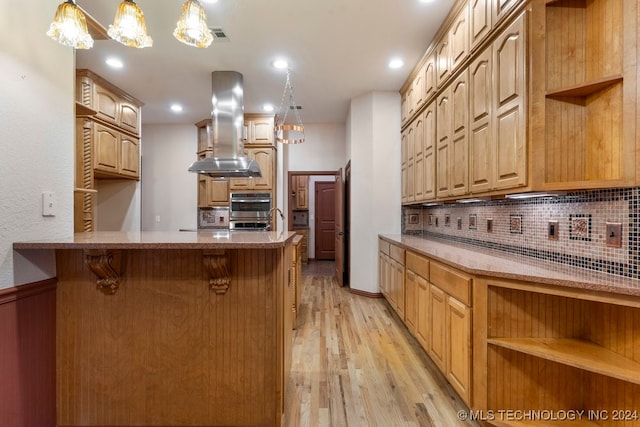 kitchen with appliances with stainless steel finishes, hanging light fixtures, island range hood, kitchen peninsula, and light wood-type flooring