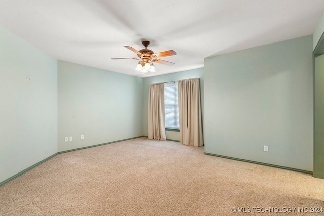 spare room featuring light carpet and ceiling fan