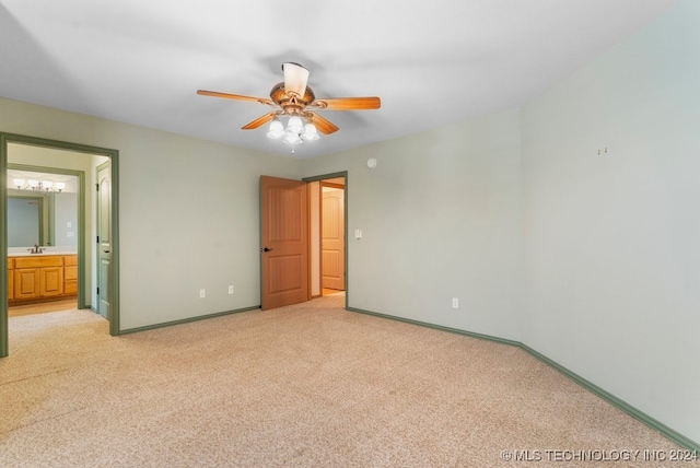 unfurnished bedroom featuring ceiling fan, light carpet, and ensuite bathroom