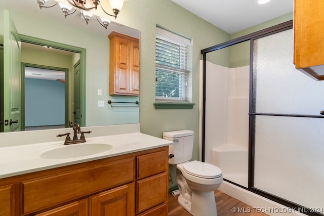 bathroom with hardwood / wood-style floors, vanity, toilet, and an enclosed shower