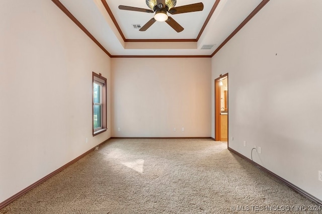 unfurnished room with a raised ceiling, ceiling fan, and light colored carpet