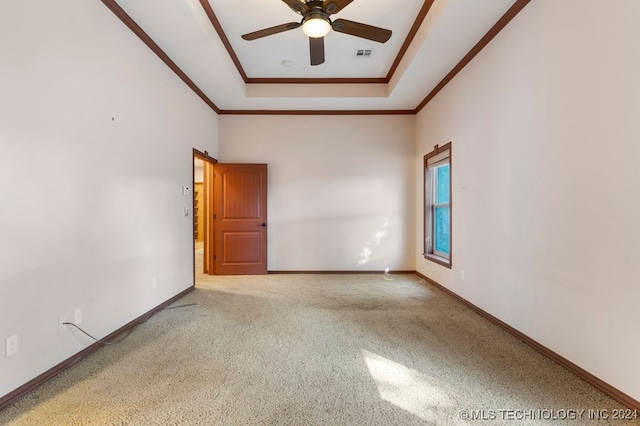 carpeted empty room featuring ceiling fan and a raised ceiling