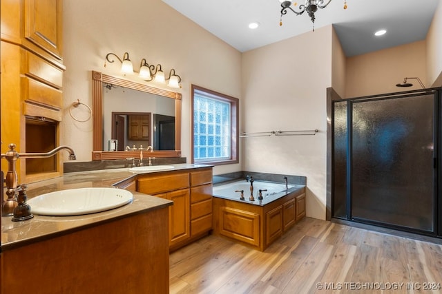 bathroom with shower with separate bathtub, a chandelier, hardwood / wood-style flooring, and vanity