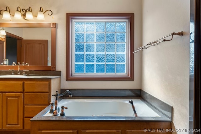 bathroom with a bathtub, vanity, and a wealth of natural light