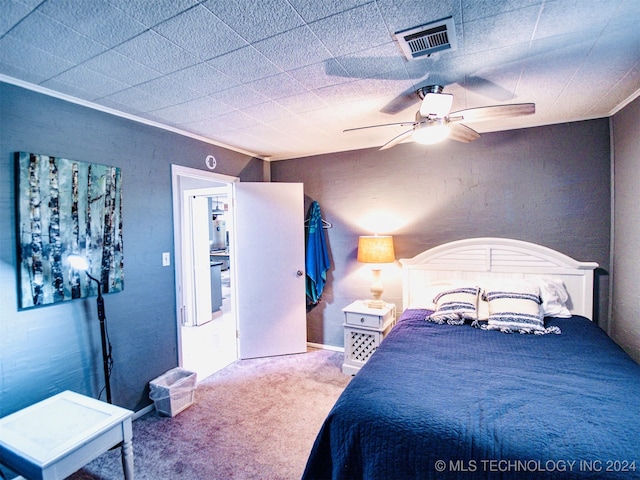 carpeted bedroom with ornamental molding and ceiling fan