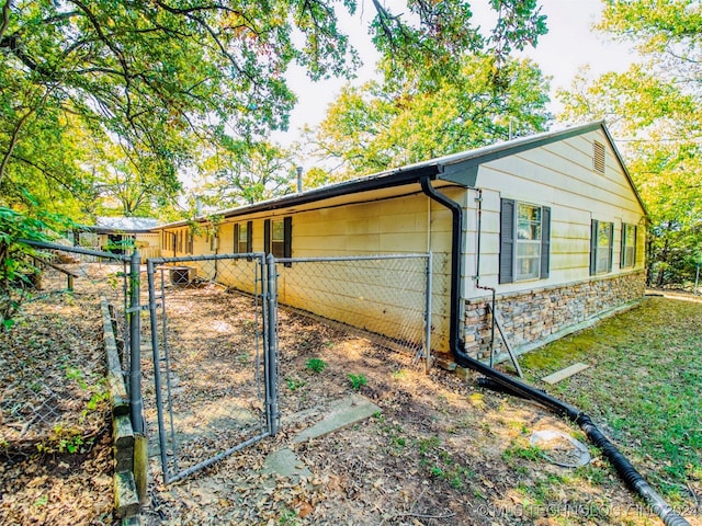 7386 Sooner Rd, Kingston, OK 73439 - view of property exterior with a gate and stone siding
