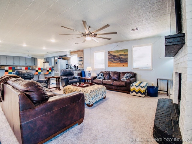 carpeted living room featuring a fireplace and ceiling fan