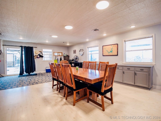 dining room with light hardwood / wood-style flooring and a healthy amount of sunlight