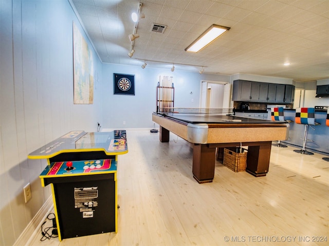 game room with light hardwood / wood-style flooring and track lighting