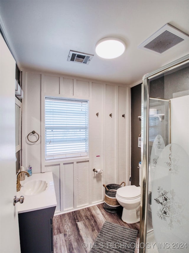 bathroom featuring walk in shower, hardwood / wood-style floors, vanity, and toilet