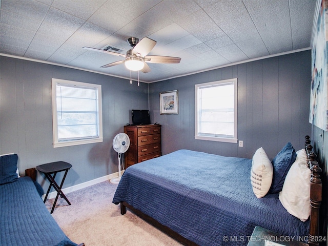 bedroom featuring carpet floors, ornamental molding, and ceiling fan