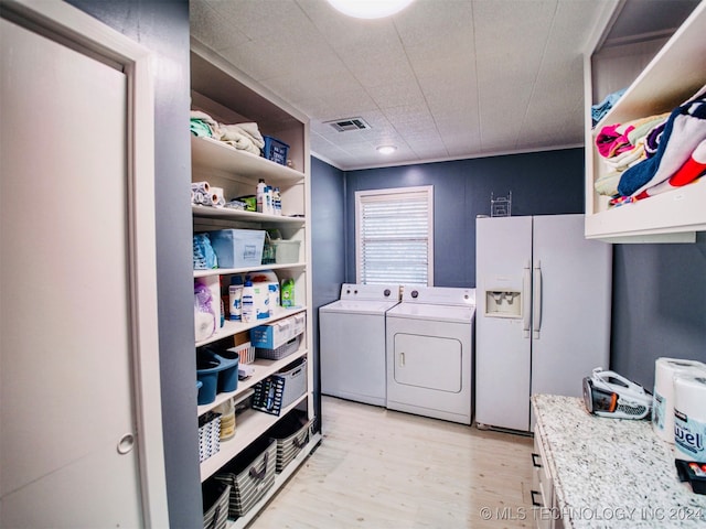 laundry area with light wood-type flooring and washing machine and clothes dryer