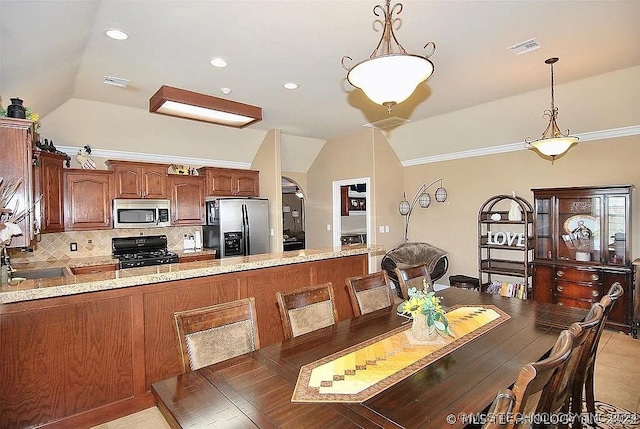 dining space featuring crown molding, light tile patterned flooring, vaulted ceiling, and sink