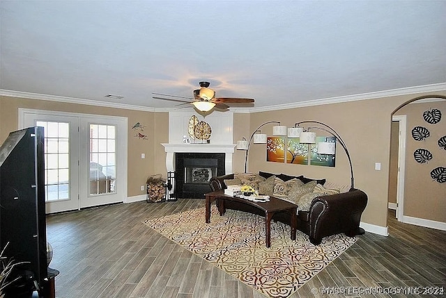 living room featuring hardwood / wood-style flooring, ornamental molding, and a large fireplace