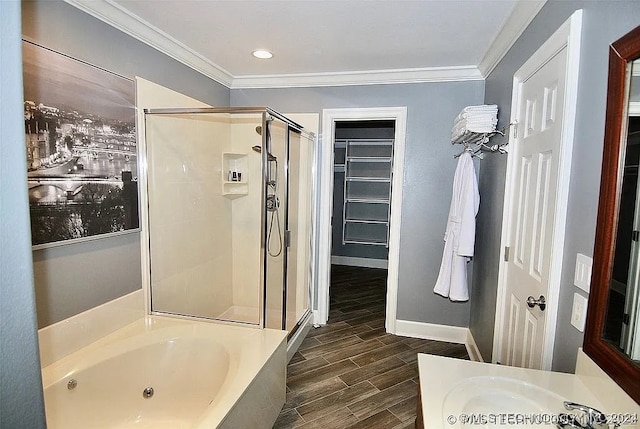 bathroom with wood-type flooring, vanity, plus walk in shower, and ornamental molding